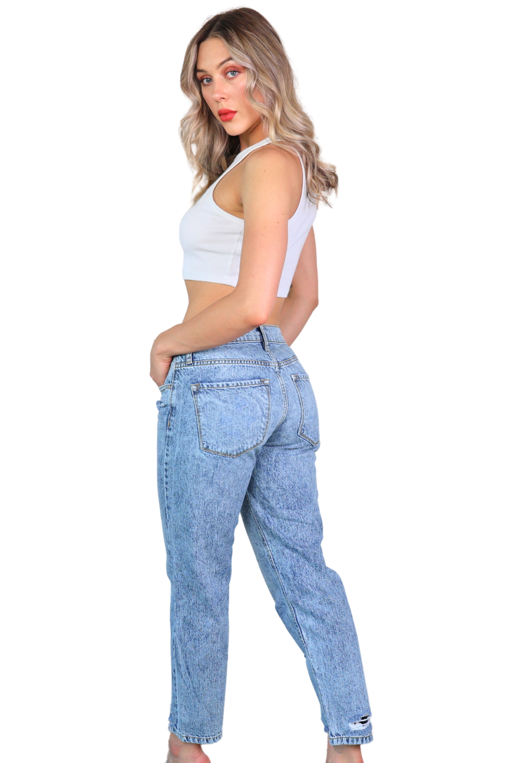 Woman wearing light blue jeans and a white top on a white background