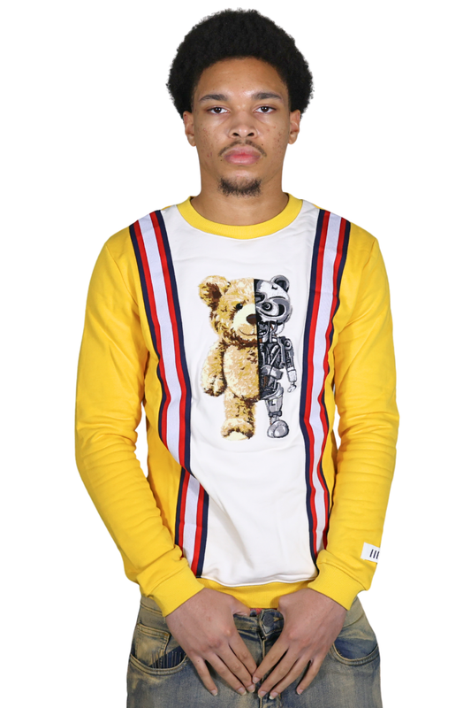 Person wearing a yellow long-sleeve shirt with a graphic design of a teddy bear and robot on a white background.