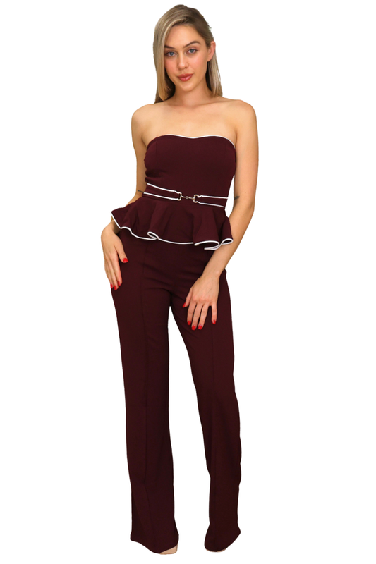 Woman wearing a strapless burgundy jumpsuit with a belt on a white background